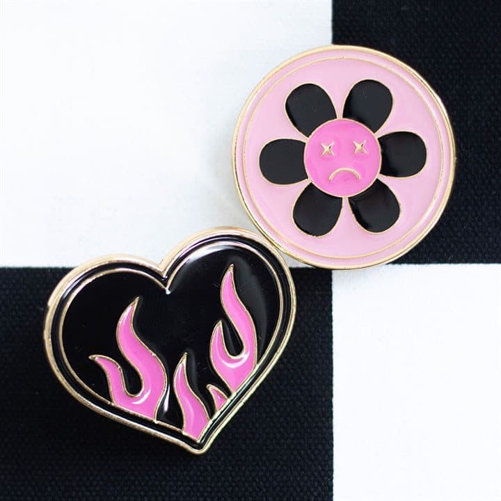 Burning heart and sad flower pin badges on a card