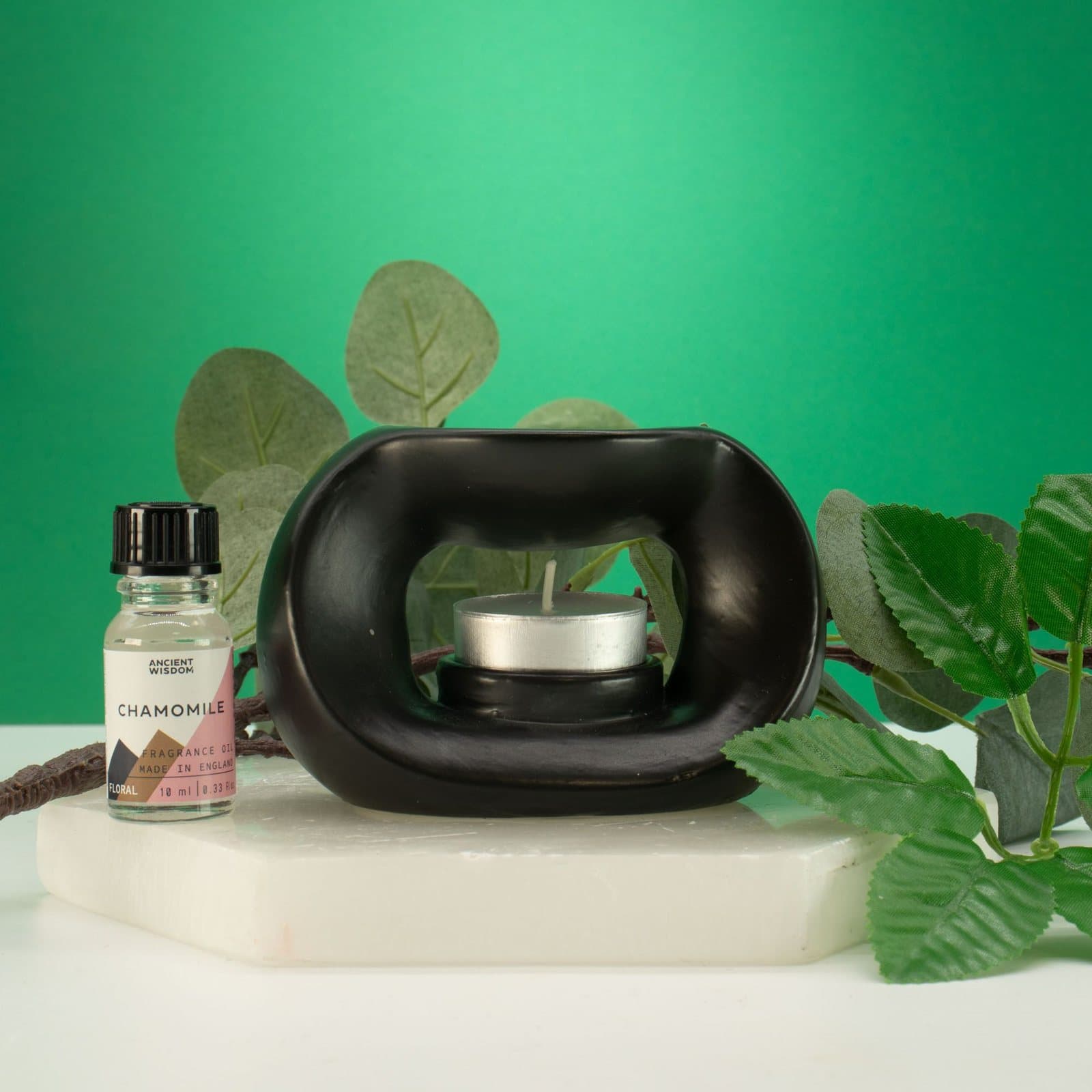 Matt black ceramic oil burner in an oval pebble shape