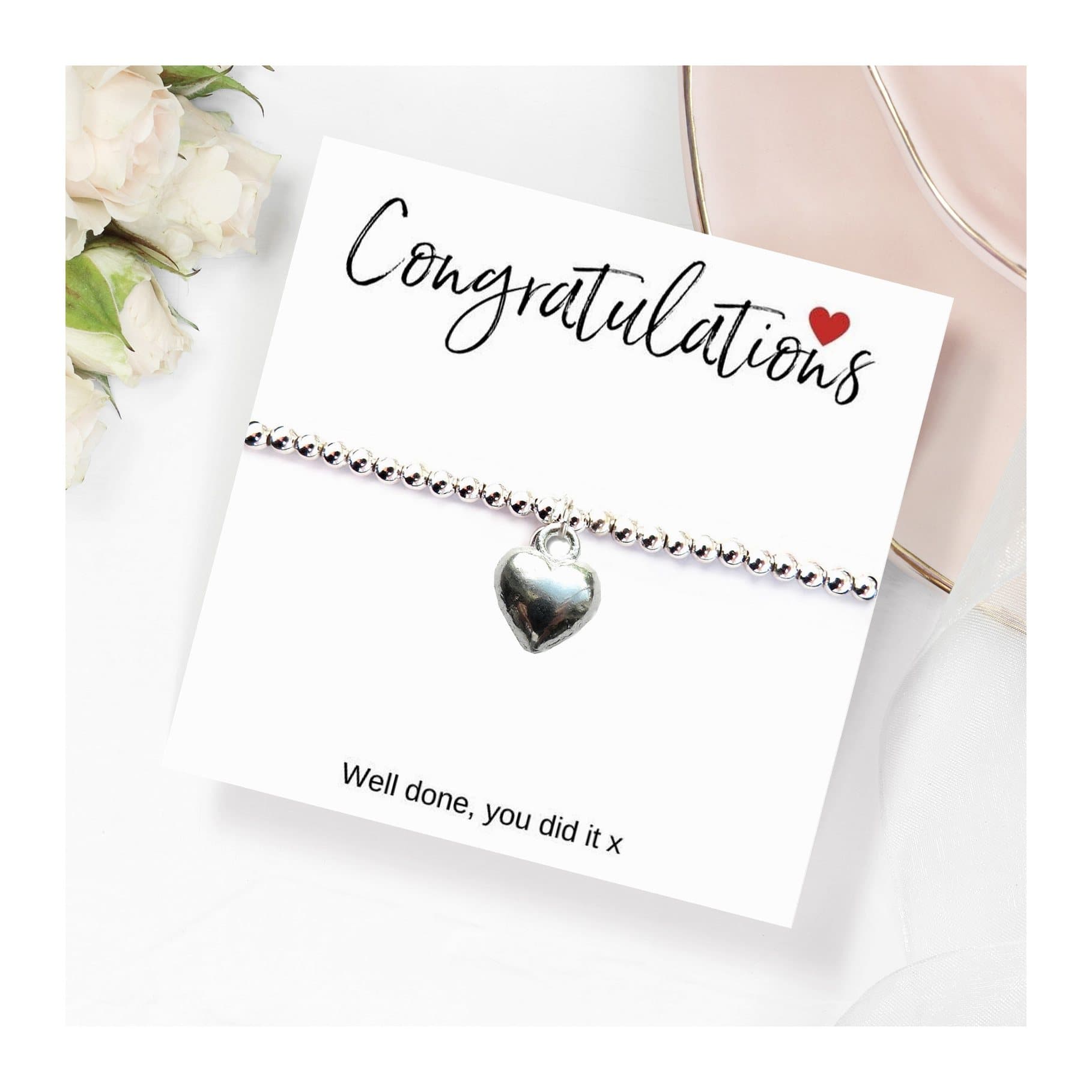 Silver heart charm stretch bracelet presented on a congratulations message card