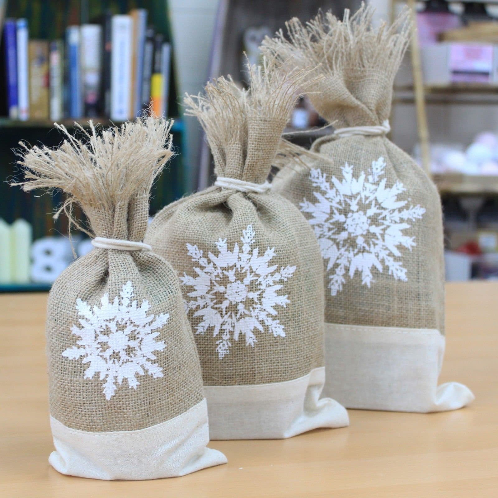 Set of three white jute pouches with a snowflake design