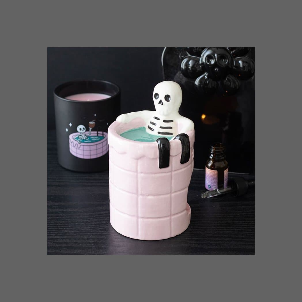 Ceramic oil burner of a skeleton soaking in a pink swimming pool