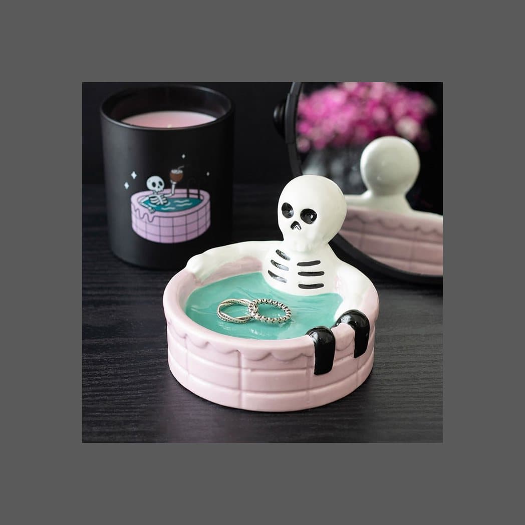 Ceramic trinket dish with a skeleton soaking in a pink swimming pool