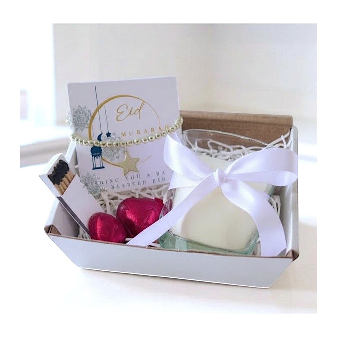 Eid Mubarak hamper: white candle in a glass jar, beaded bracelet, red chocolate hearts