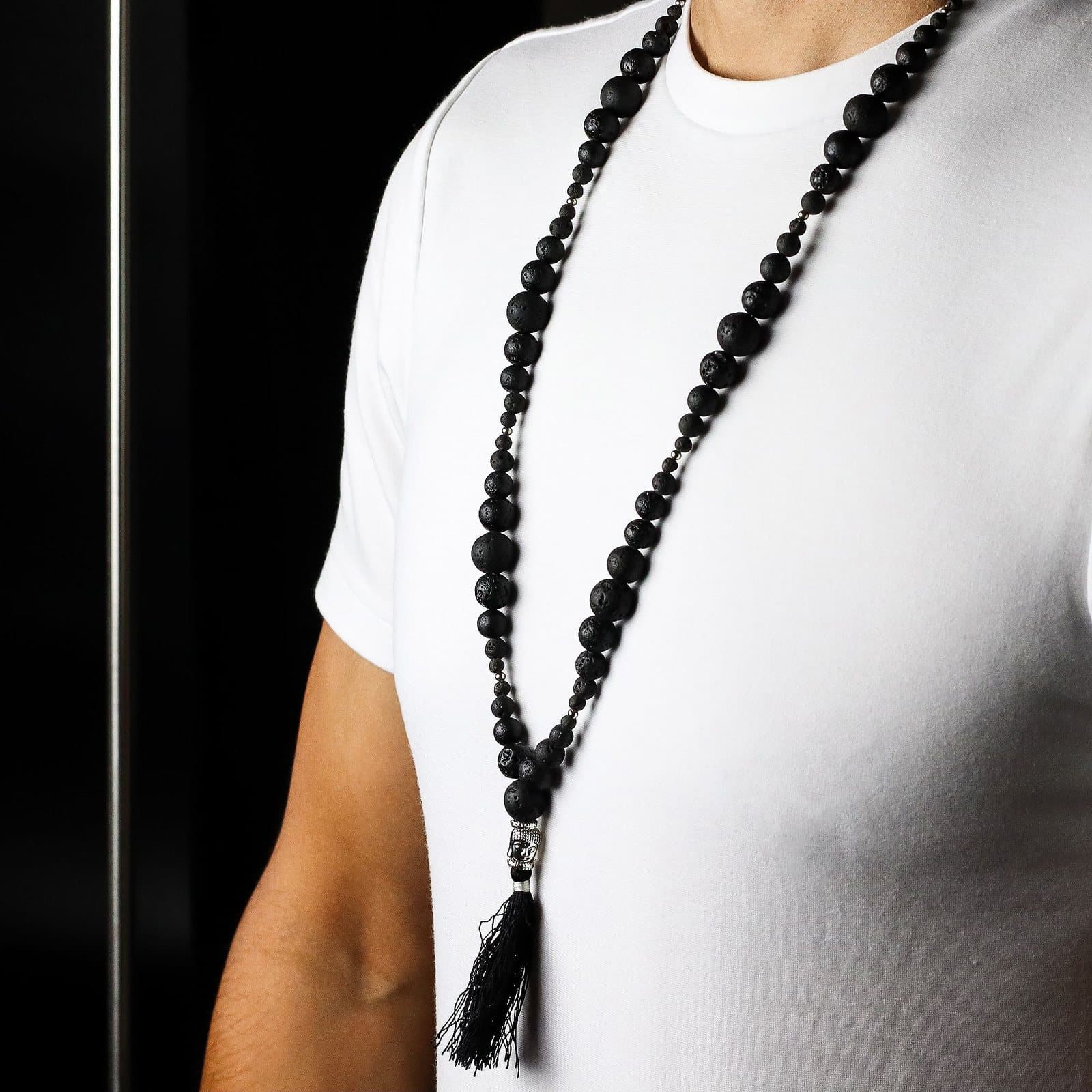 Lava stone necklace with a silver Buddha charm and tassel