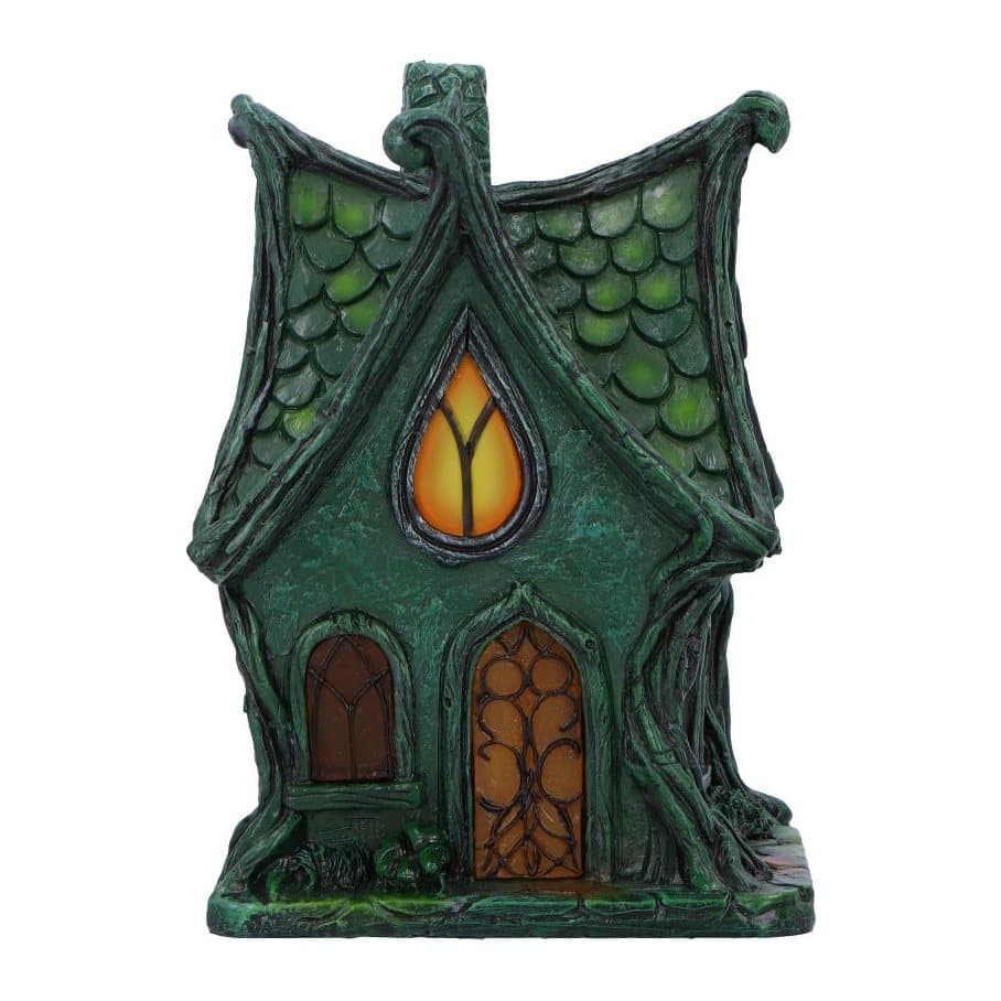Gothic-inspired fairy cottage with dark green scale-like roof and lit windows