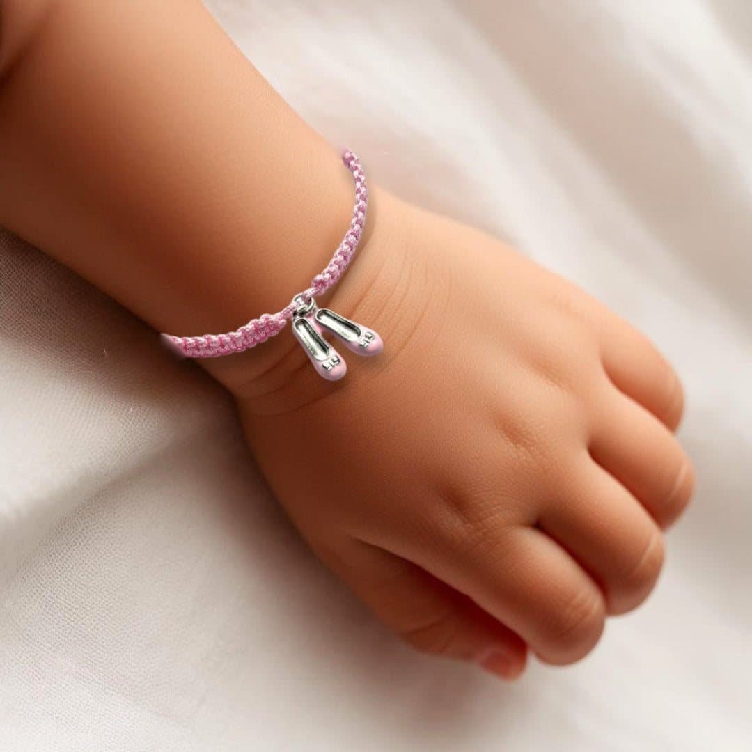 Pink ballet shoe charm on a braided cord bracelet