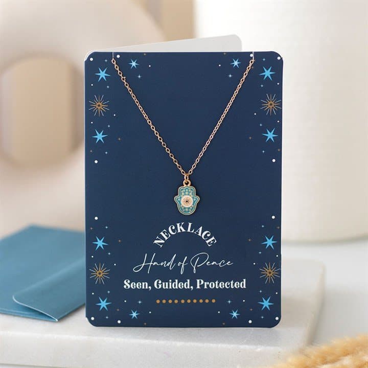 Turquoise Hamsa necklace on a dark blue greeting card