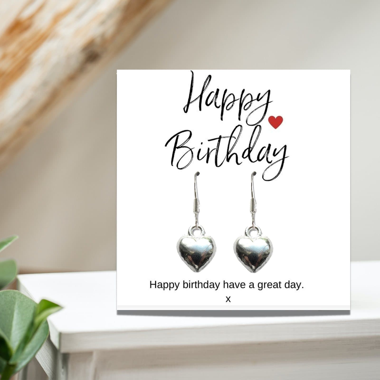 Silver heart earrings on a Happy Birthday message card