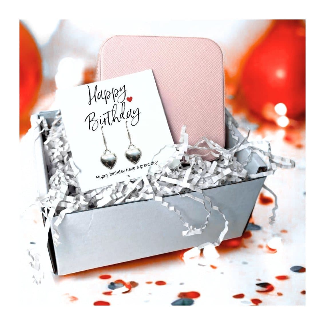Silver heart earrings on a birthday message card, with a pink square jewellery box