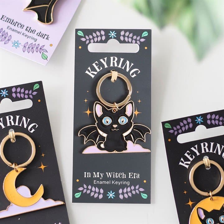 Enamel keyring of a cute bat-winged black cat on a matching backing card