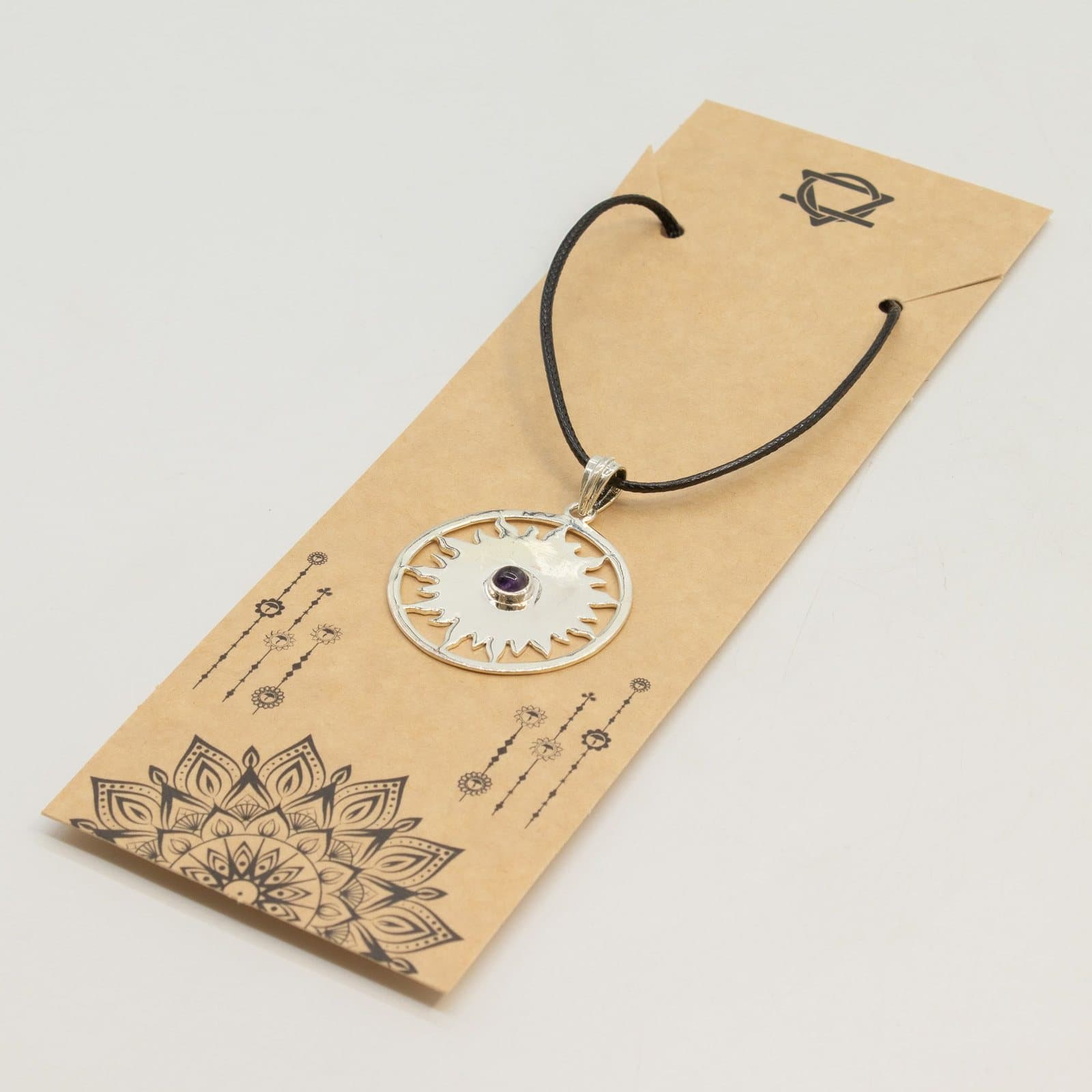 Silver-plated sun pendant with a purple stone at the centre on a black cord