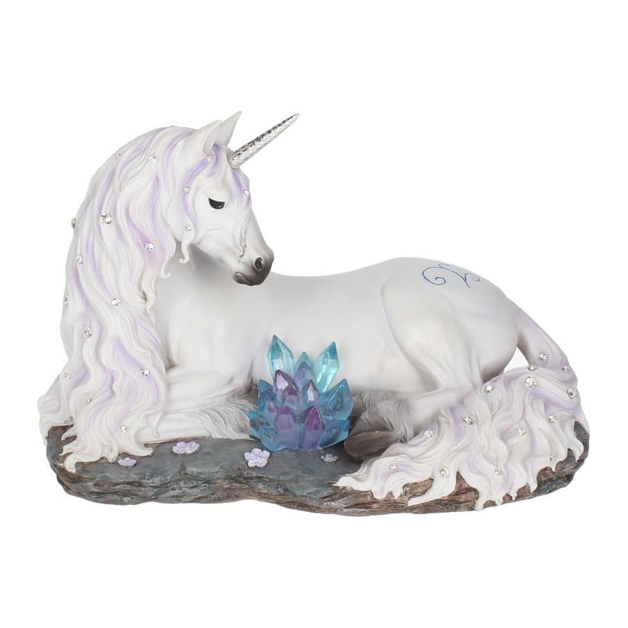 White unicorn reclining on a rock with blue and purple crystals and pink flowers