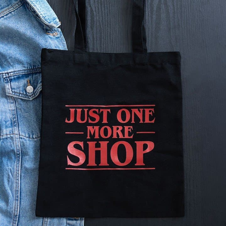 Black tote bag with bold red Just One More Shop text