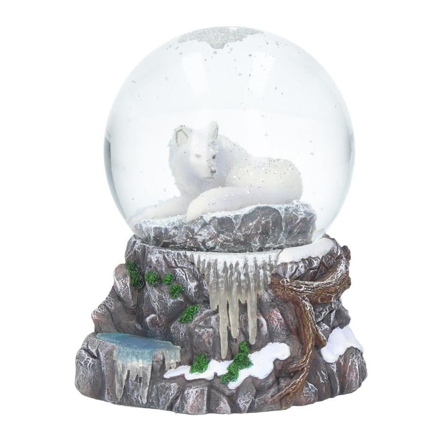 Snow globe with a white wolf under a full moon on snowy rocks