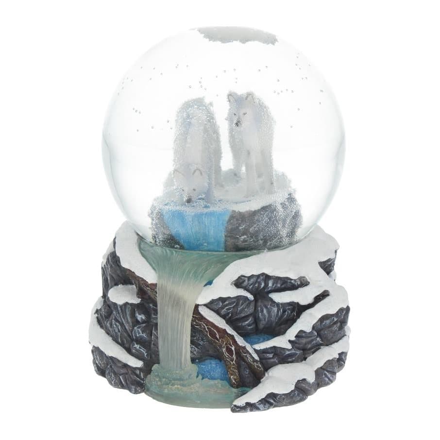 Snow globe with two wolves by a pool on a stand of snow-covered rocks