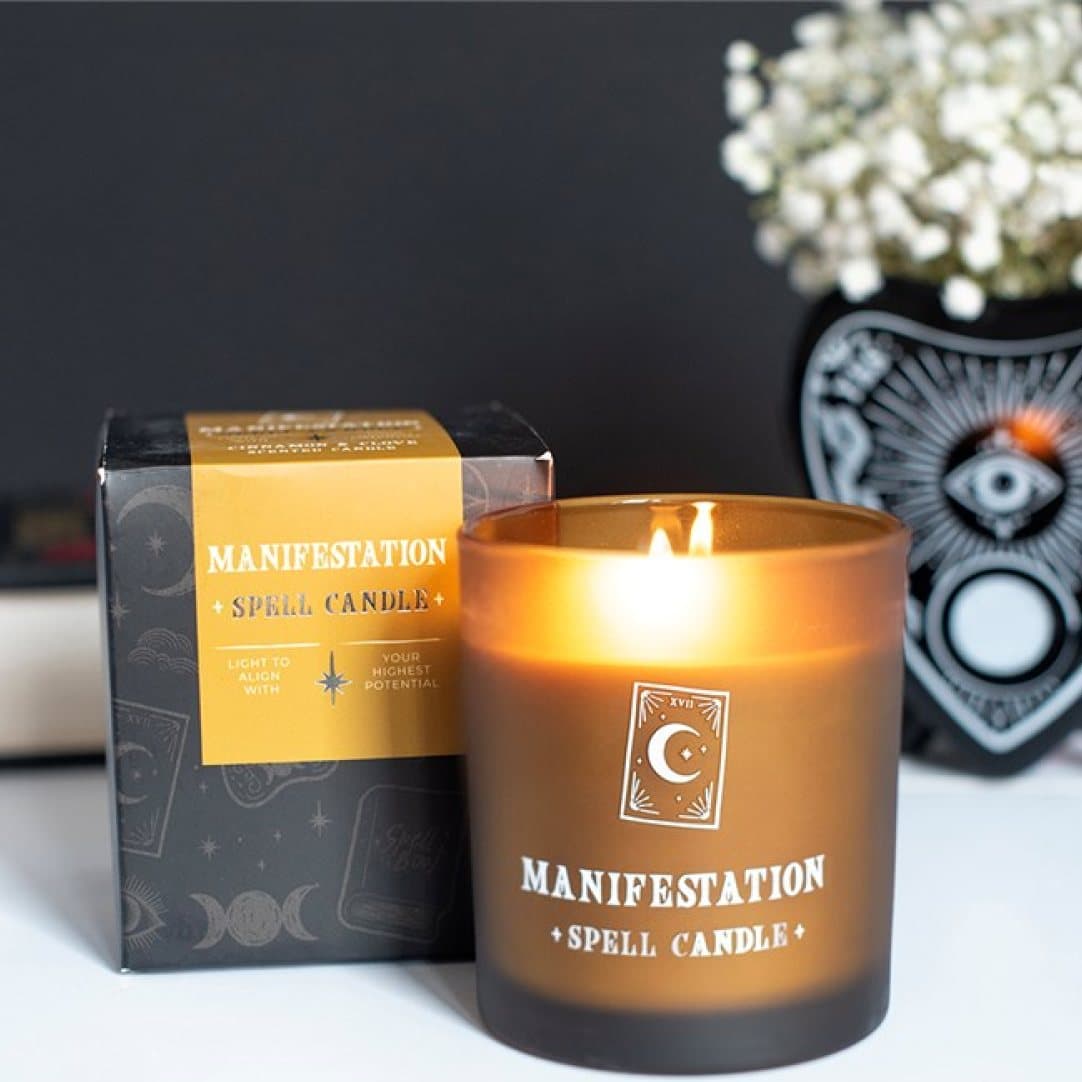Manifestation cinnamon and clove candle in a golden glass jar with tarot-inspired design