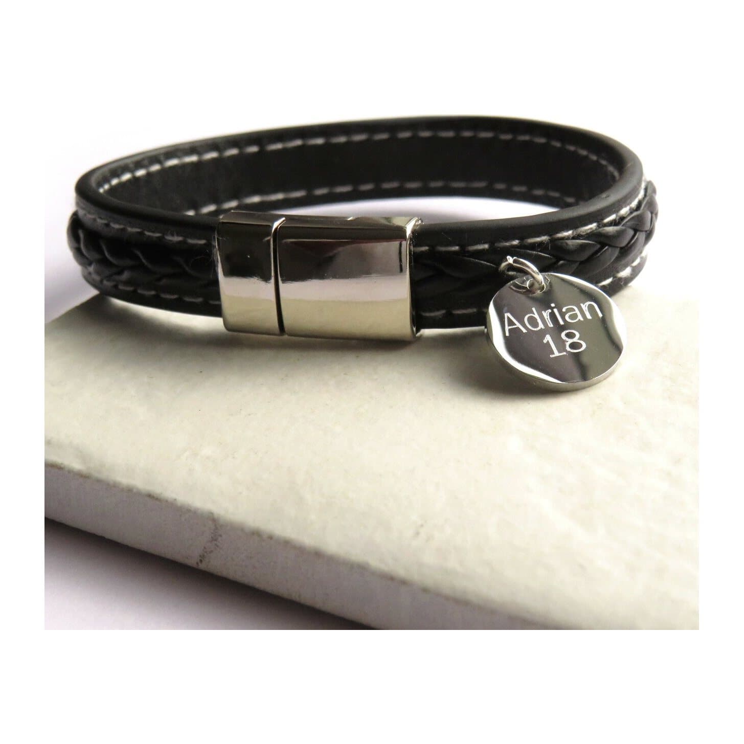 Black stitched faux leather bracelet with a silver stainless steel disc.