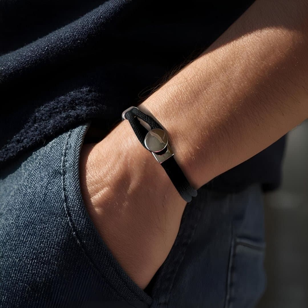 Men's black braided bracelet with a silver button clasp