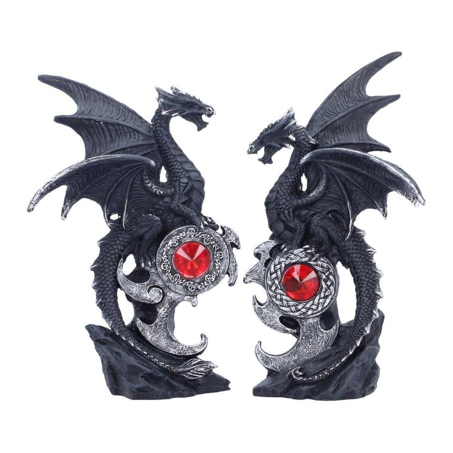 Two black dragon figurines facing each other on a rocky base with a red gemstone
