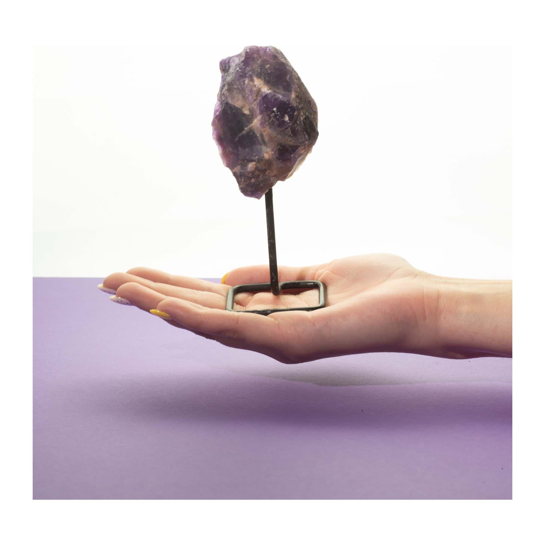 Raw amethyst mineral specimen on a black metal stand