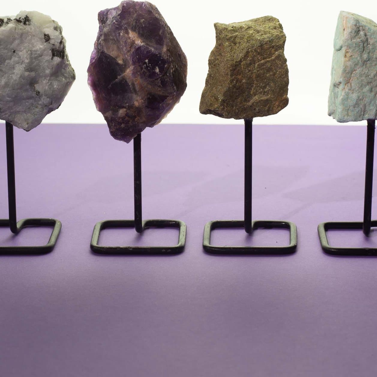 Epidote mineral specimen mounted on a black metal stand