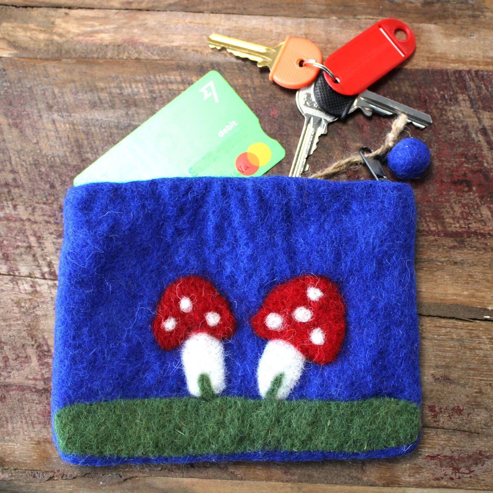 Three felt zipper pouches with red white-spotted toadstools and felt-ball zip pulls