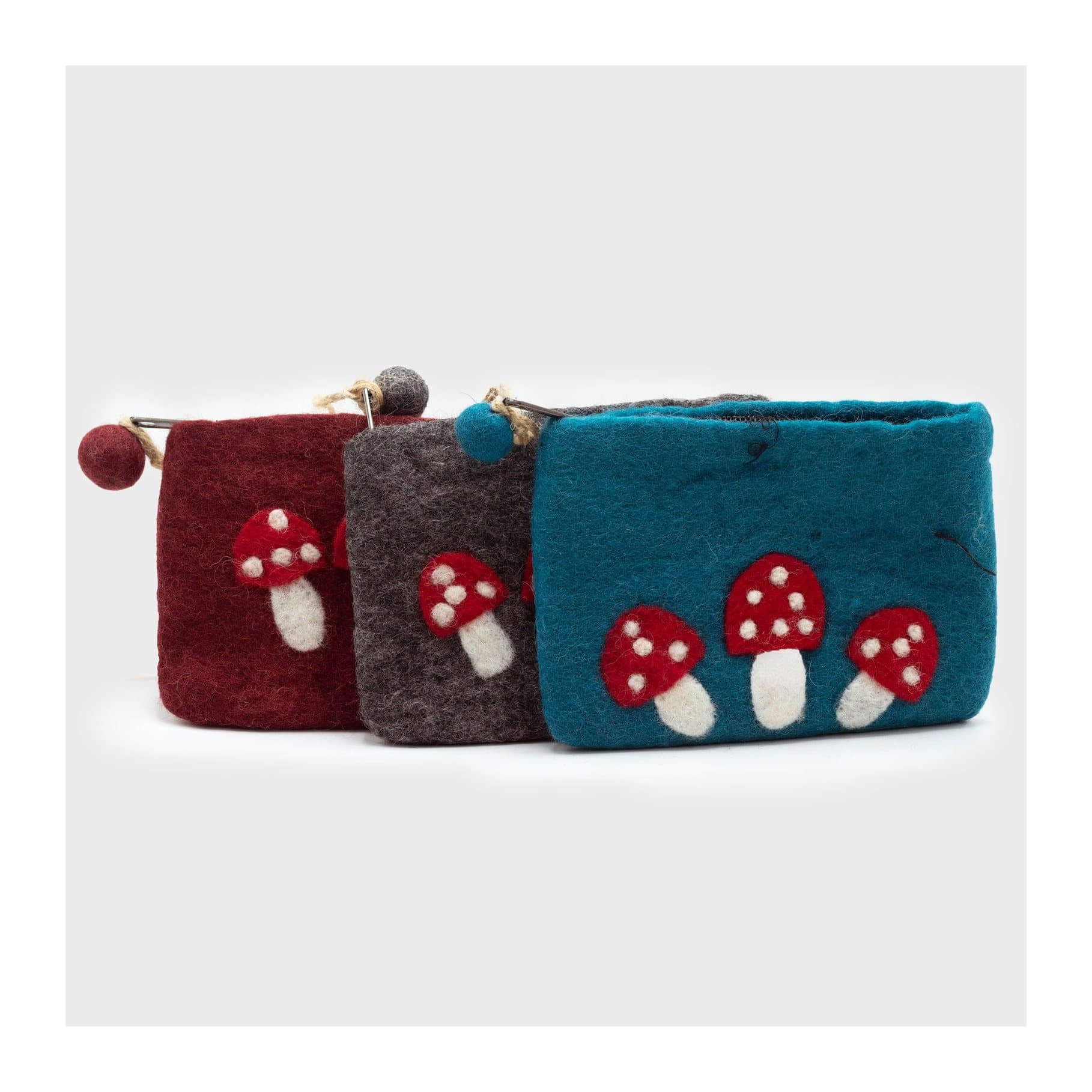 Three felt zipper pouches with red-and-white mushroom designs