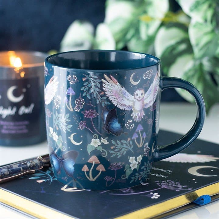 Navy mug printed with flying owls, crescent moons and plants