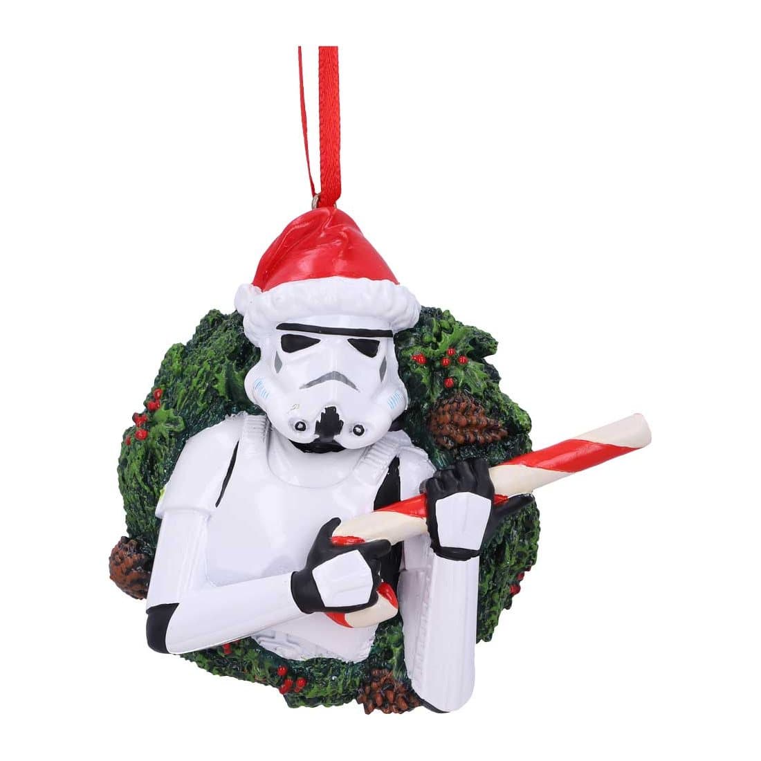 Stormtrooper ornament holding a candy cane in front of a Christmas wreath