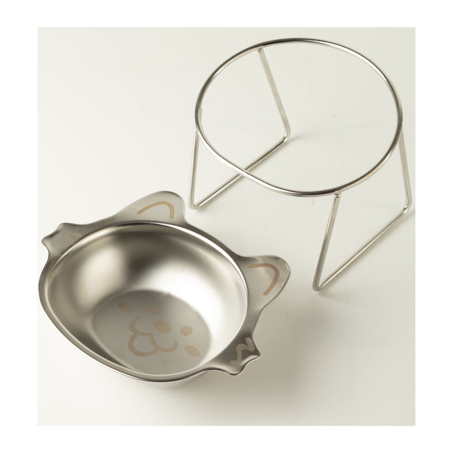 Stainless steel cat bowl with pointed ears resting in a raised metal stand