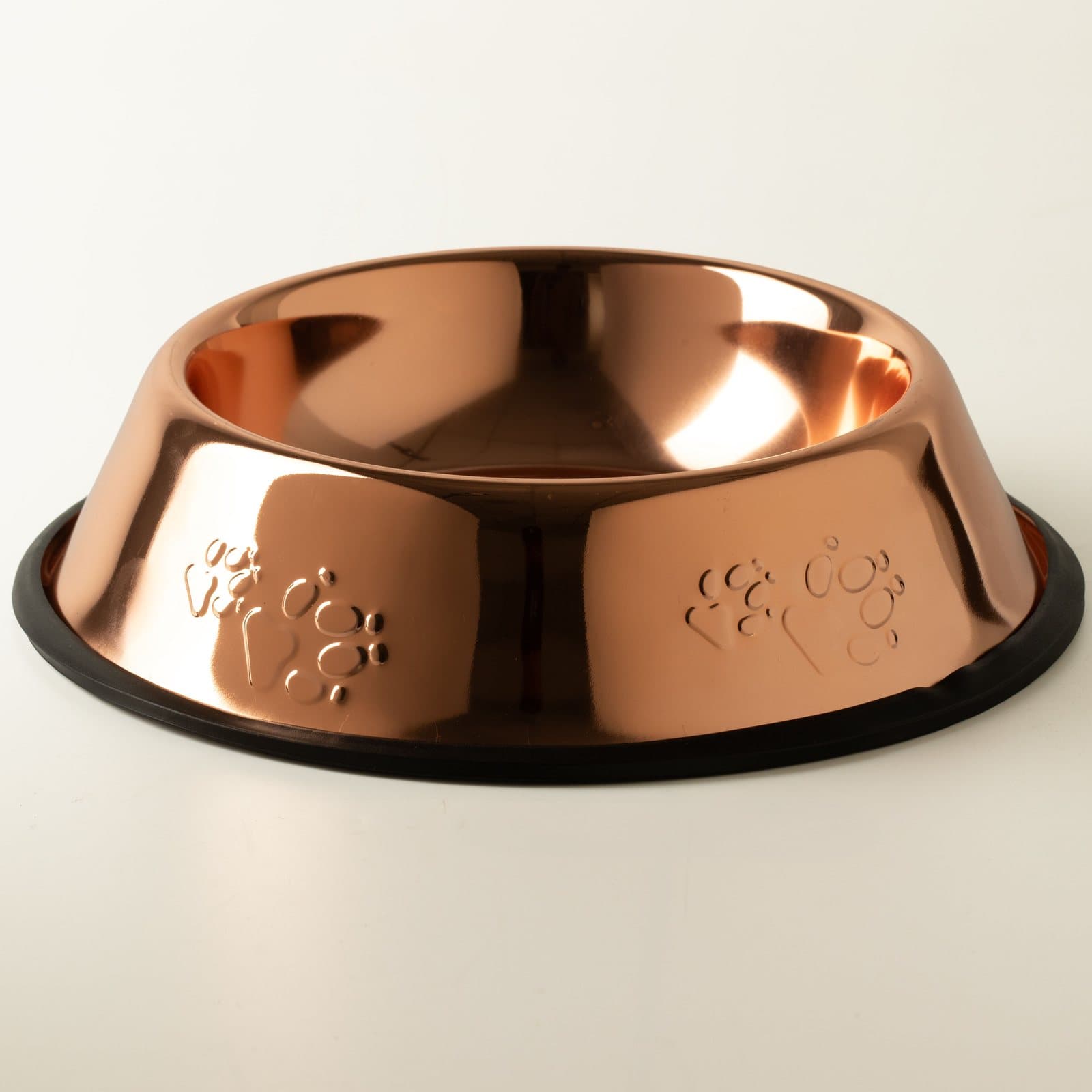 Copper-style stainless steel pet bowl with embossed paw prints and a black edge