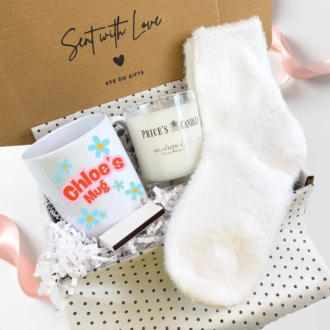 Personalised blue daisy mug, scented candle, fluffy socks and matches in a gift hamper
