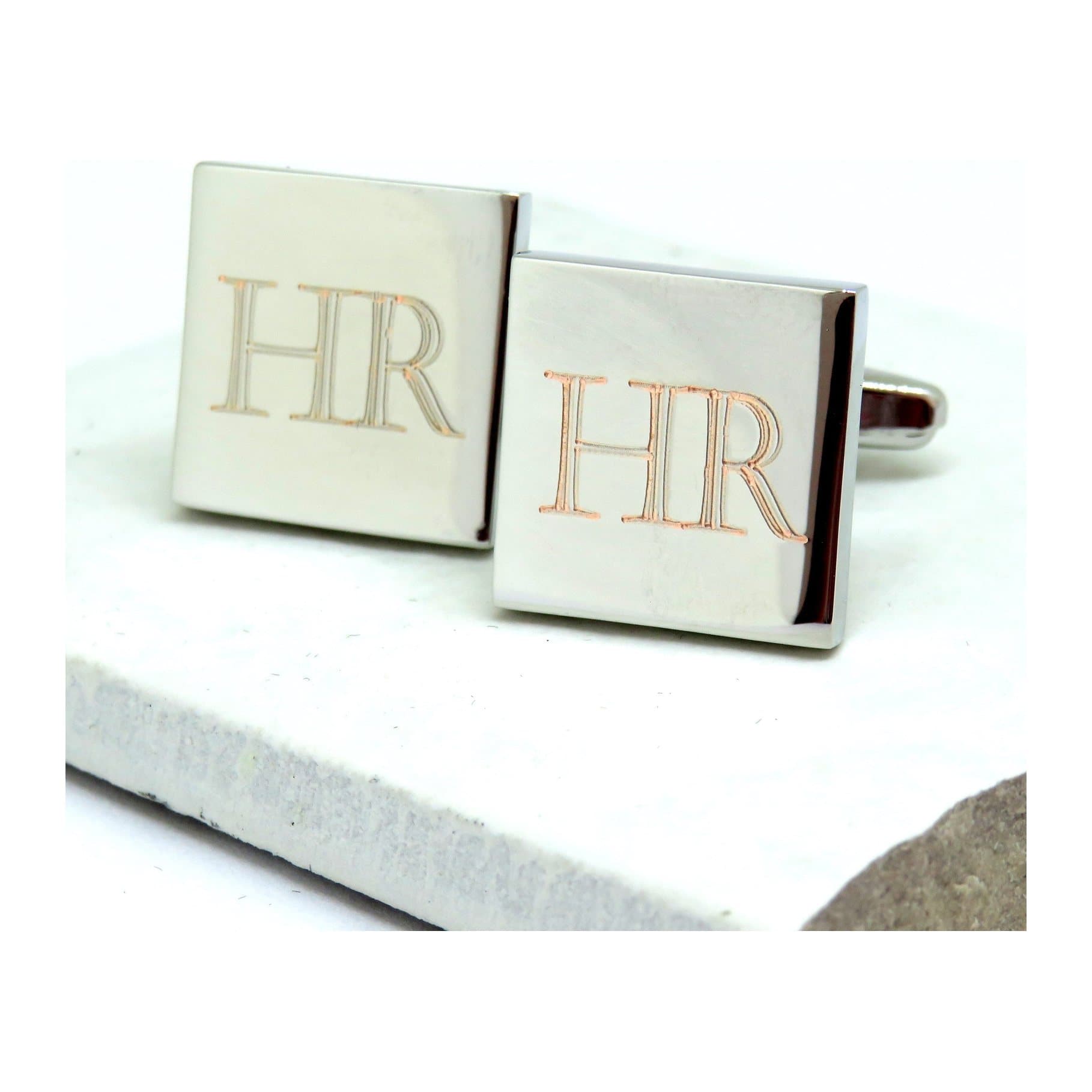 Silver-coloured square cufflinks with engraved initials in Castellar font