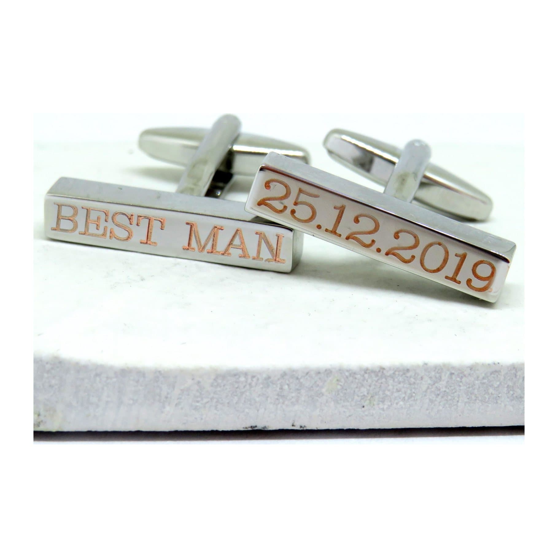 Silver bar cufflinks with an engraved name on a plain background