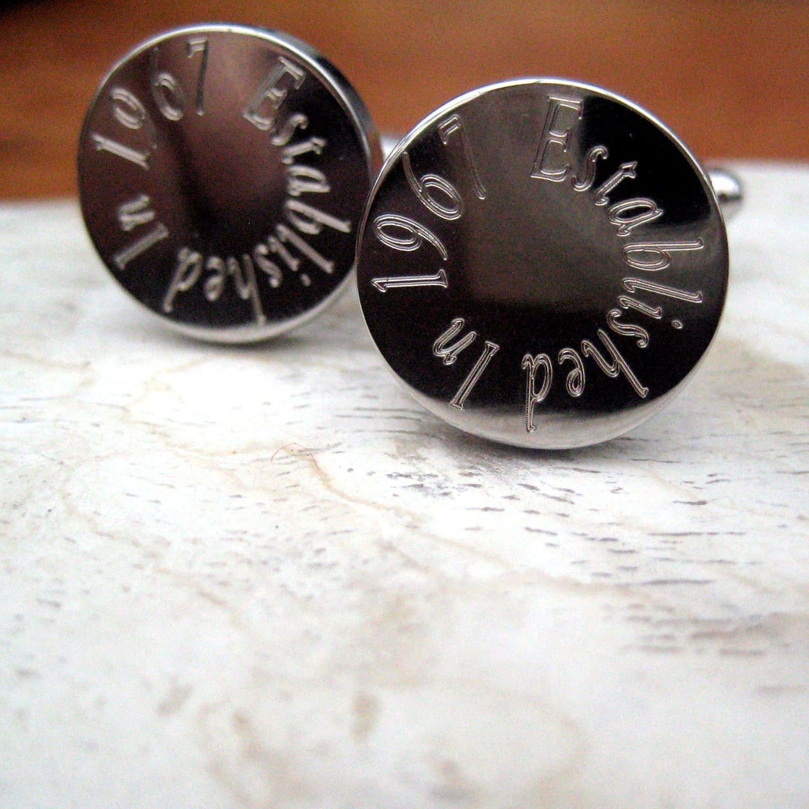 Personalised round silver-coloured cufflinks with an engraved name