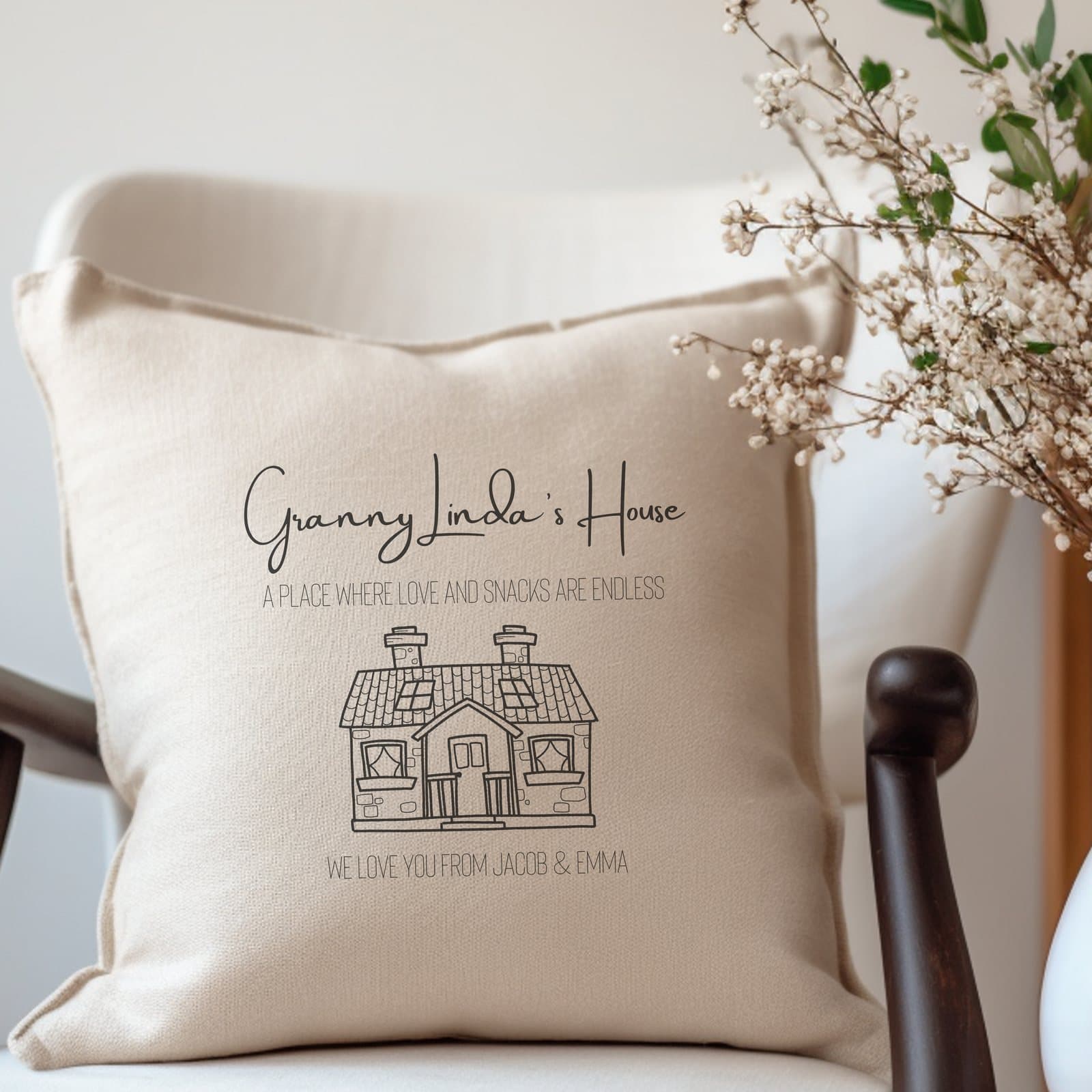 Cream cushion with a cute house and the words A place where love and snacks are endless