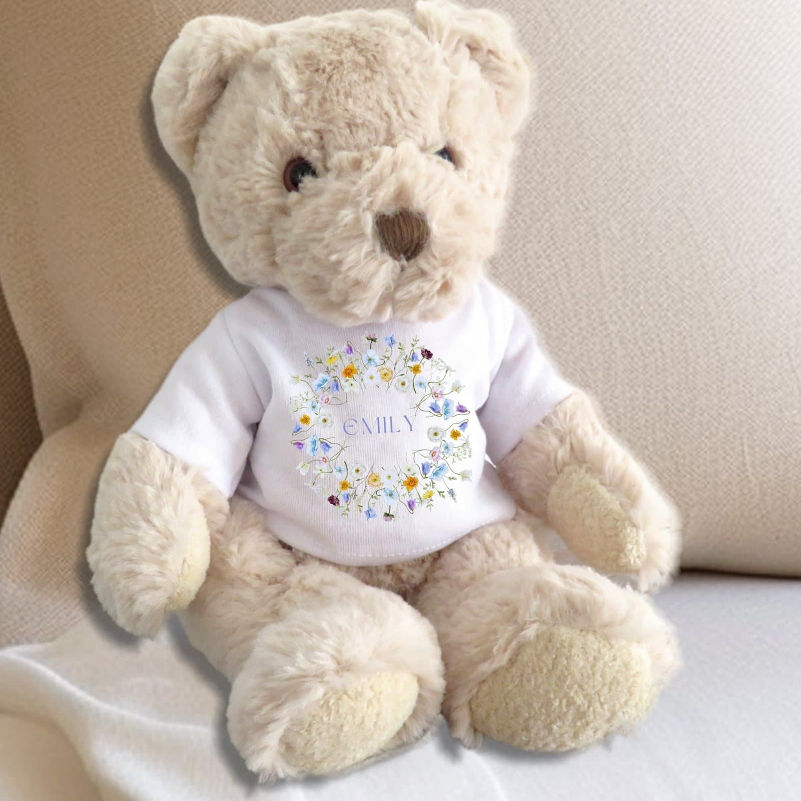 Teddy bear in a T-shirt with a circle of yellow, purple, cream and pink flowers