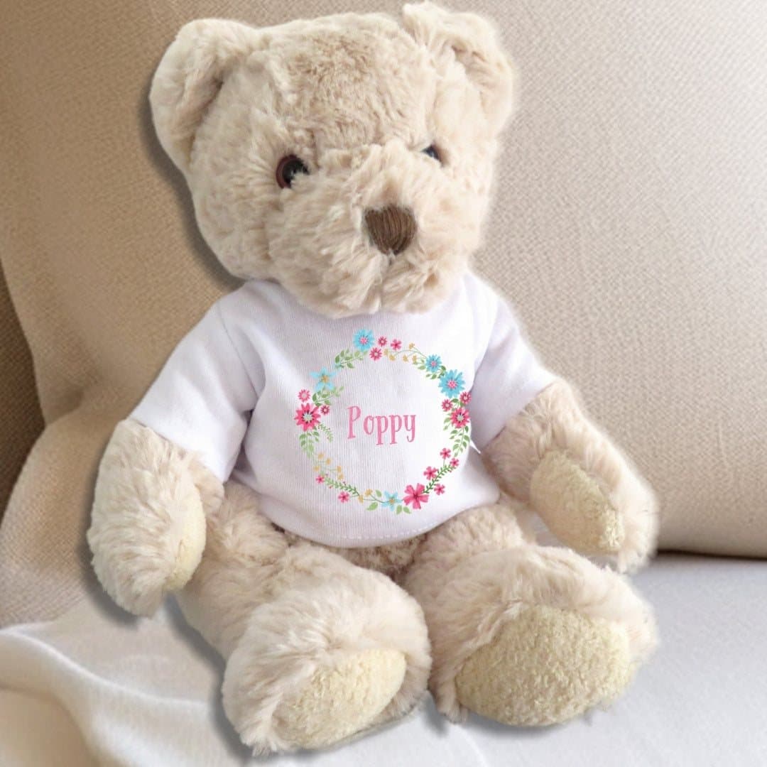 Teddy bear in a pink floral T-shirt with pink, blue and yellow blooms