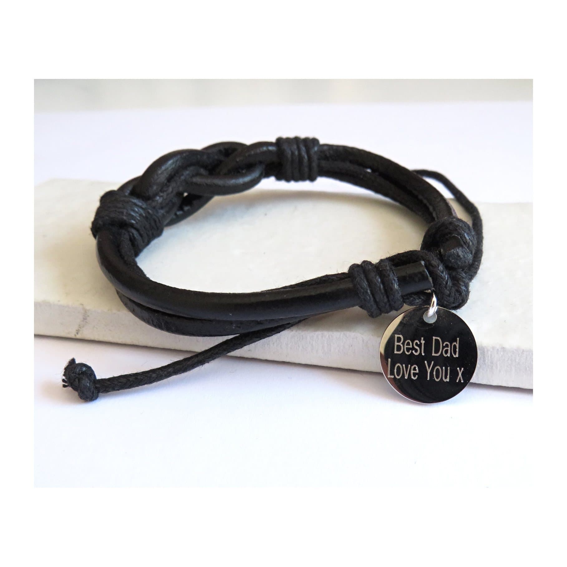 Personalised men's leather knot bracelet with a steel disc and leather and wax cord.
