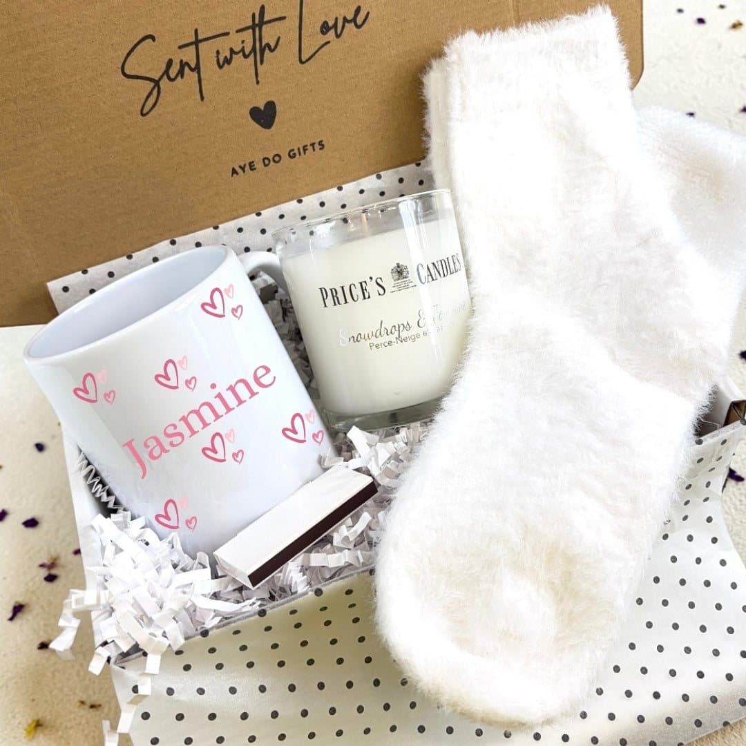 Pink hearts mug, fluffy socks, scented candle and matches in a gift hamper