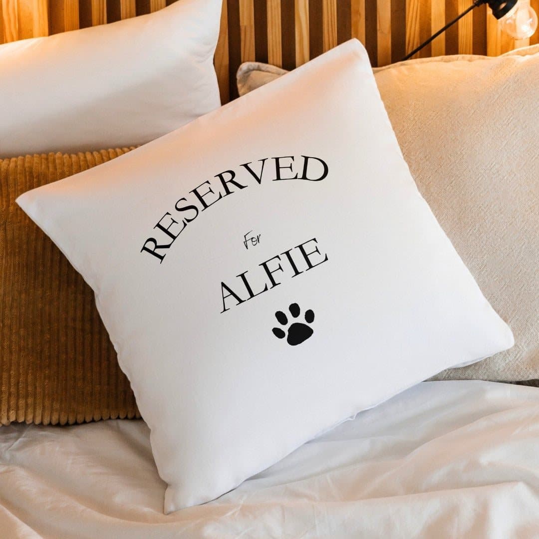Cream cushion with a paw print design and a personalised name