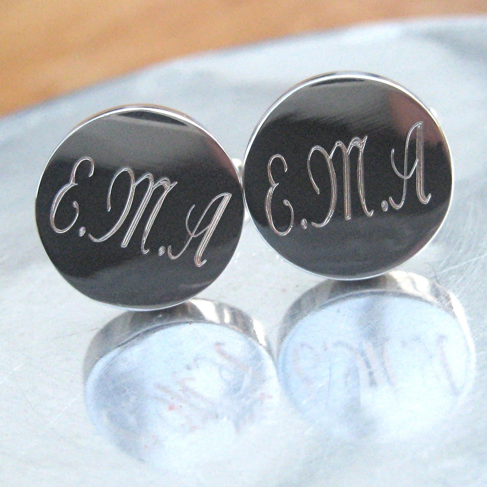 Round silver-coloured personalised cufflinks engraved with a name in script
