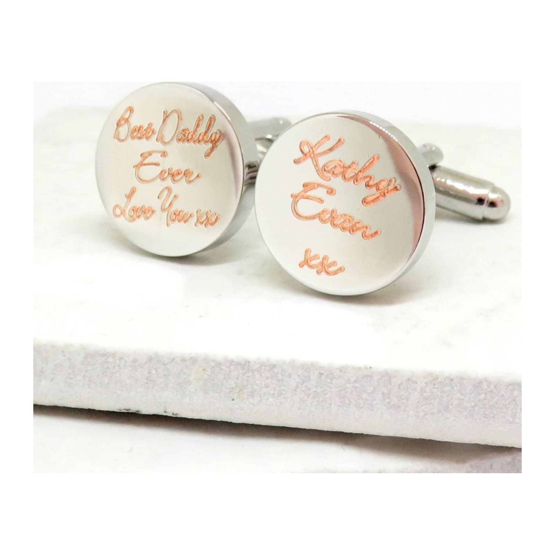 Round silver-coloured cufflinks with a name engraved in handwritten script