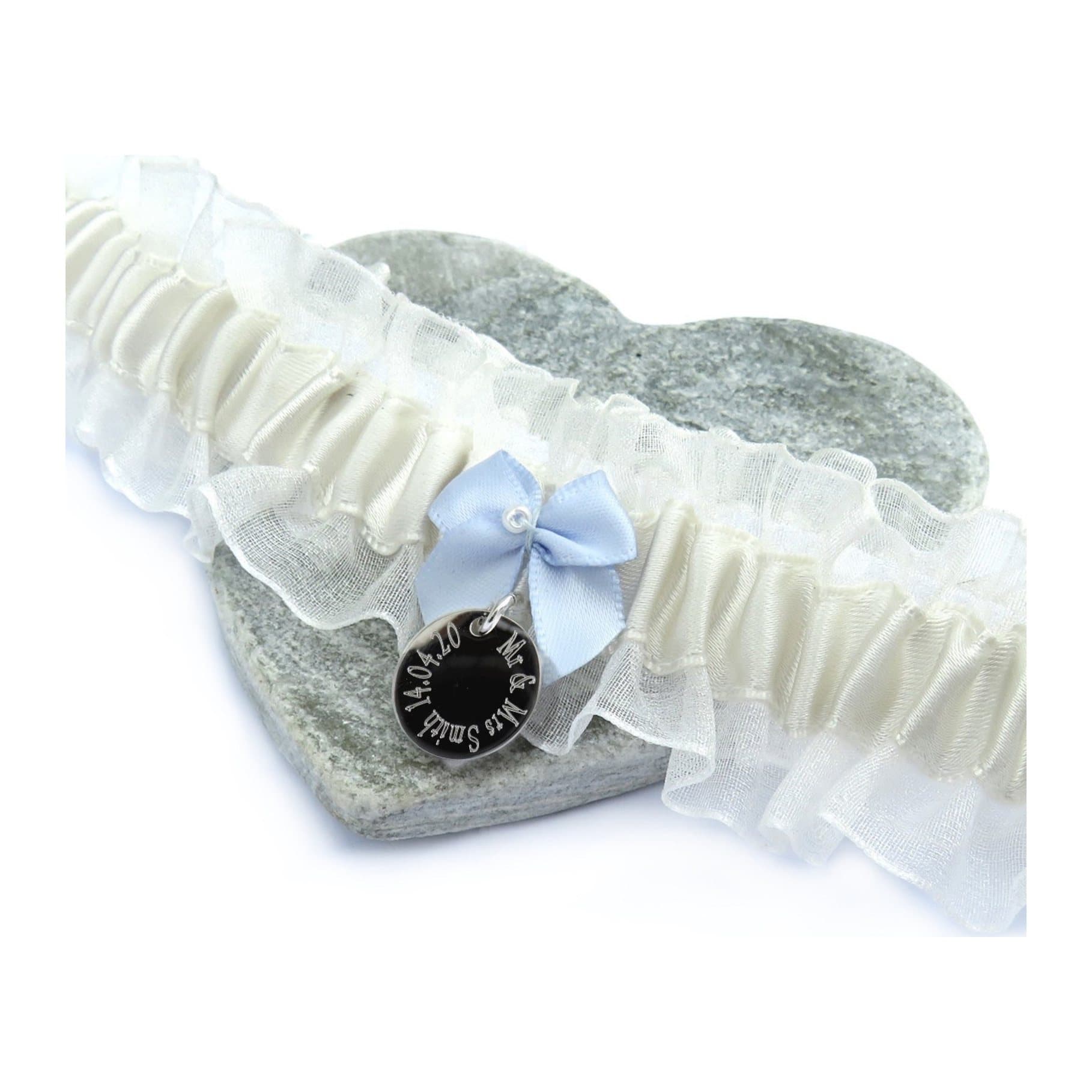 Ivory wedding garter with a blue bow, a pearl and an engraved silver disc