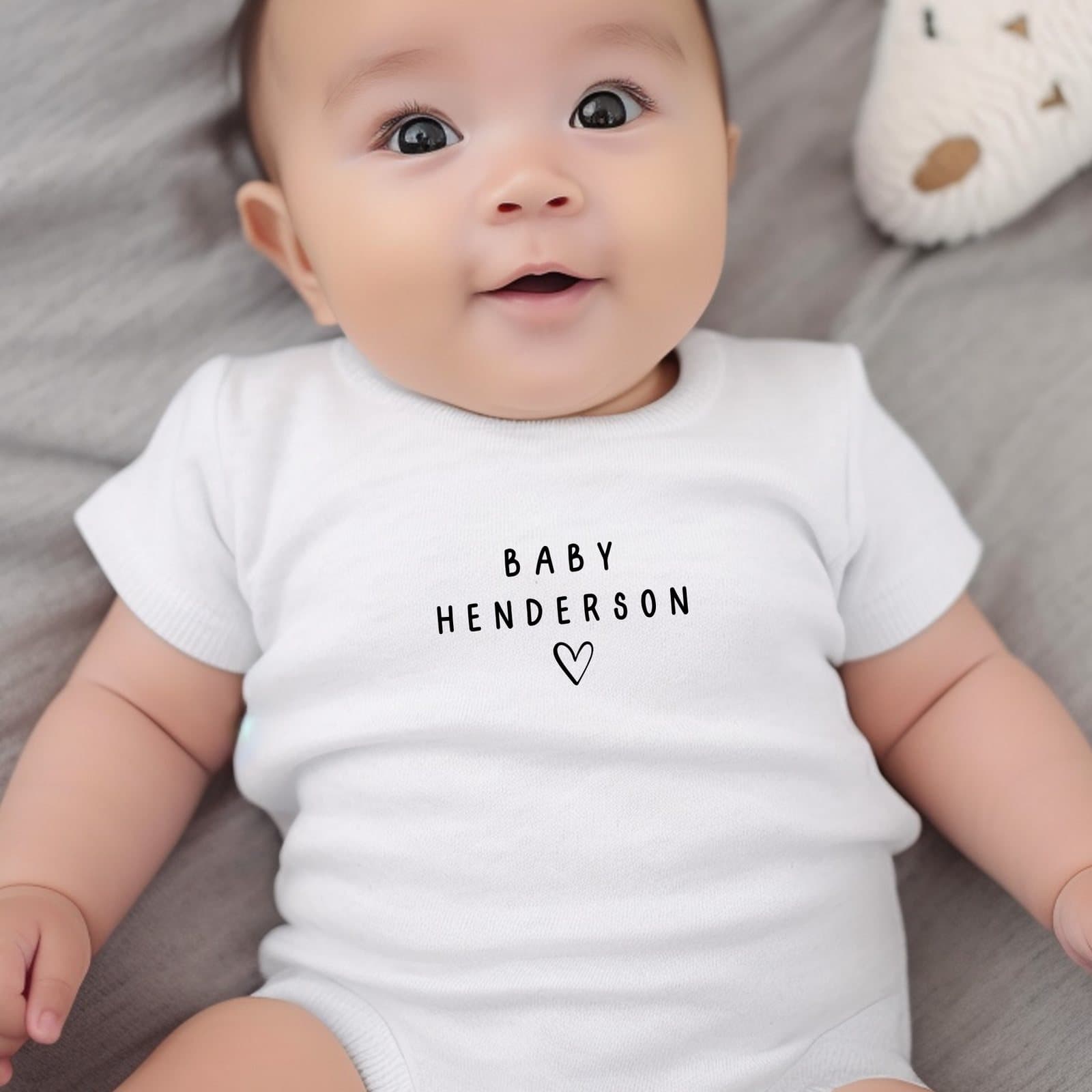 Black personalised surname baby grow, vest or bib with a name design