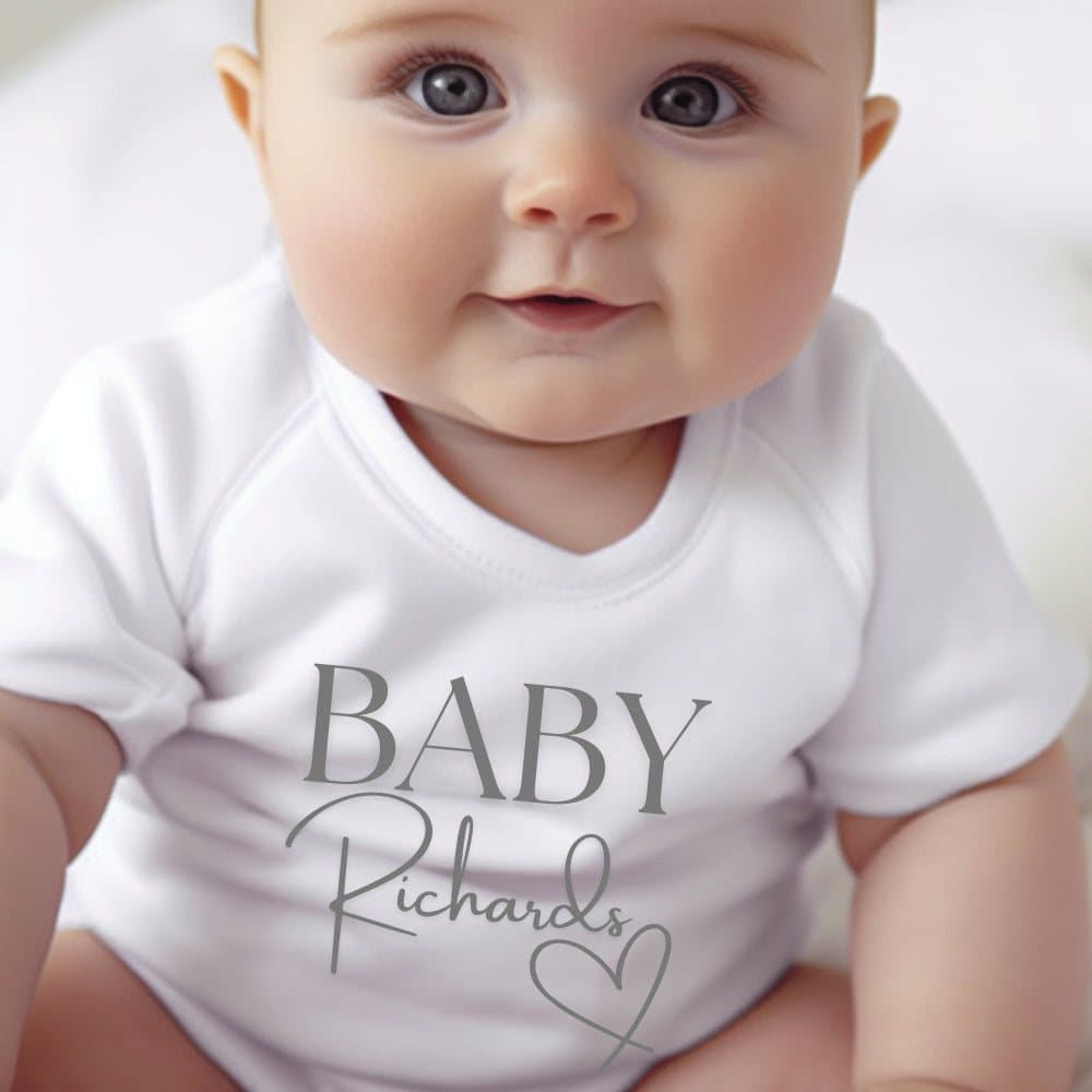 Personalised baby vest, baby grow or bib with a name and the Surname Heart design