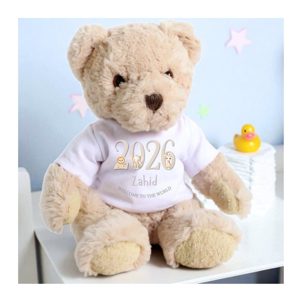 Taupe teddy bear wearing a jungle-animal T-shirt printed with Welcome to the World