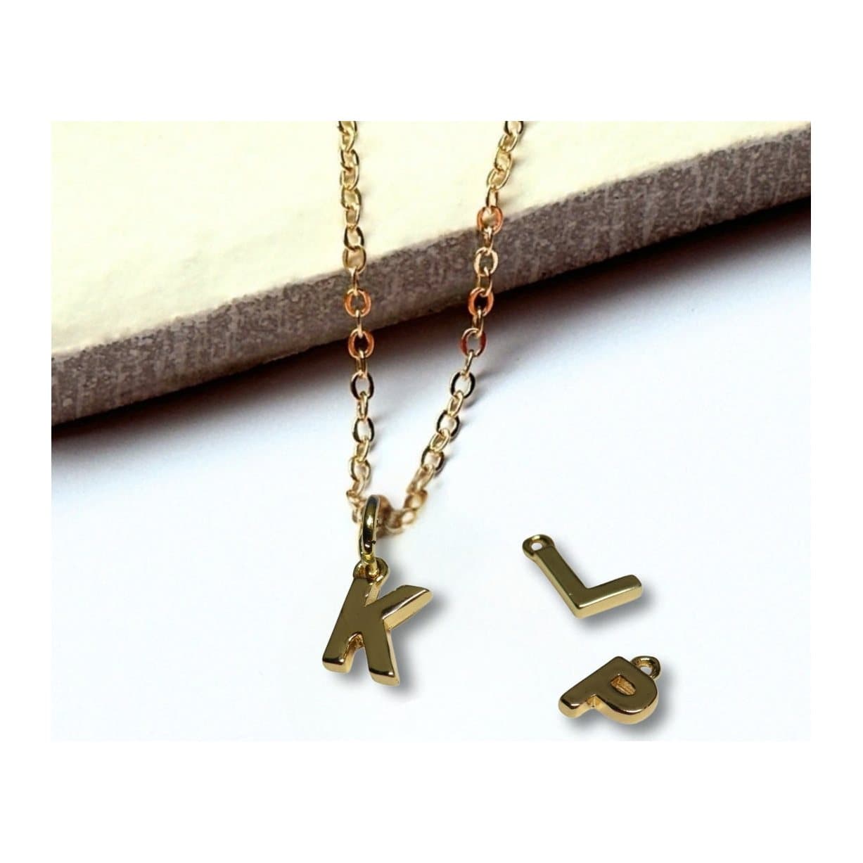 Tiny gold initial letter pendant necklace on a fine chain