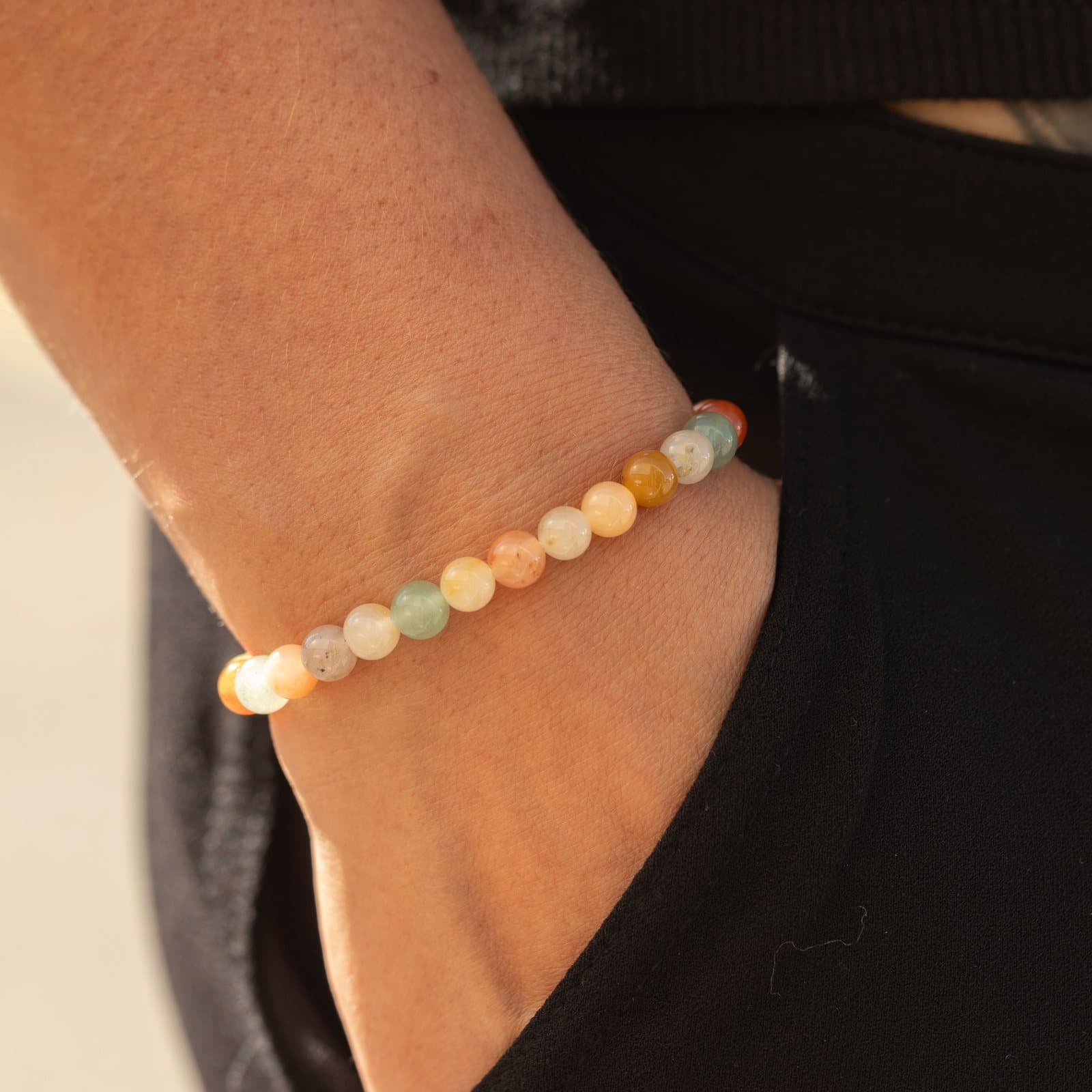 Rainbow agate bracelet of polished gemstone beads in orange, yellow, cream and green