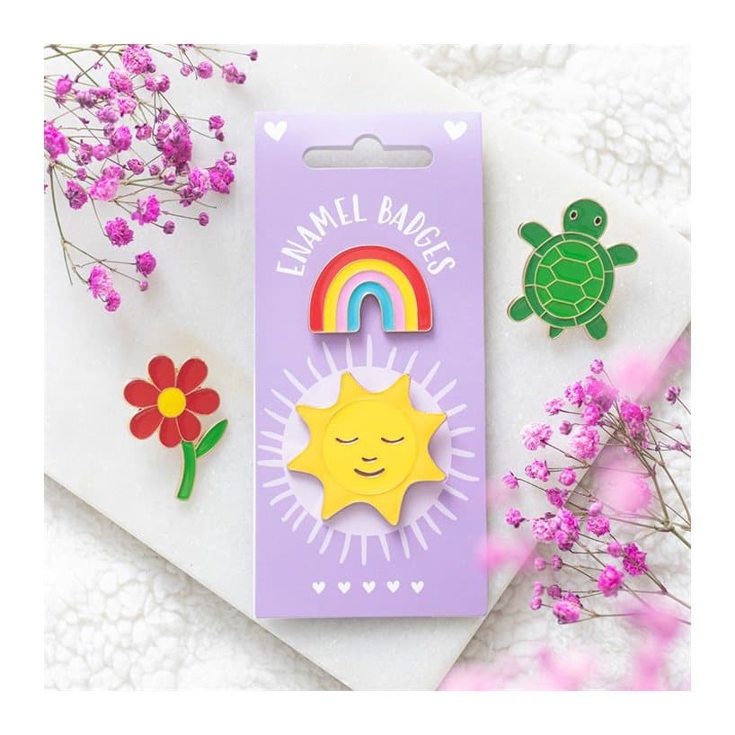 Rainbow and smiling golden sun enamel pin badges on a cardboard back